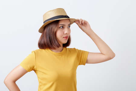 Young woman wearing yellow shirt hat and jeans shorts on whiteの写真素材