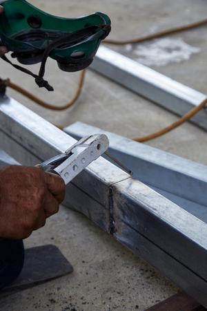 Asian man worker making sparks while welding steelの写真素材