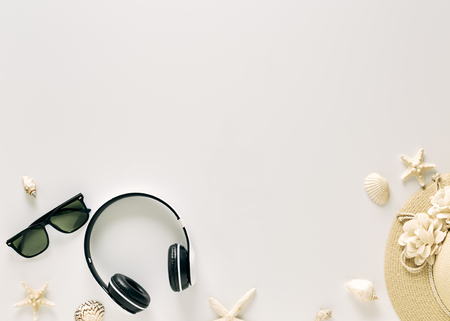 Straw hats, music headphones, sunglasses, shells on white background,  with empty space for text. Travel and fashion concept. Vacation summer sales.の写真素材