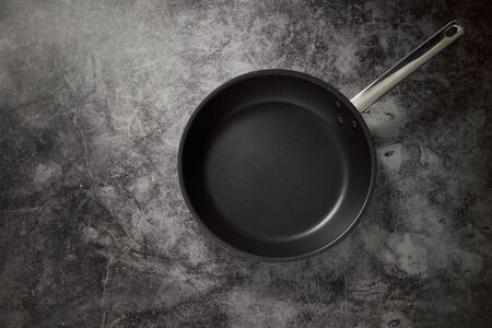 Empty Frying Pan Black ON Dark Stone work Surface copy space for text,  Culinary Background