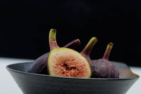 Raw fresh figs in dish organic food black background