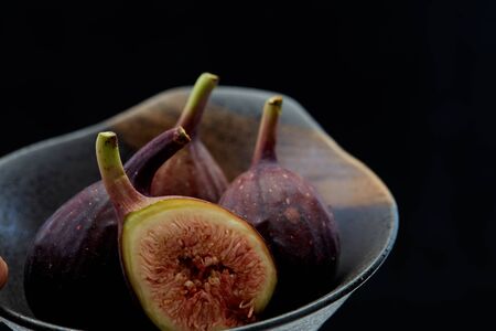 Raw fresh figs in dish organic food black backgroundの写真素材