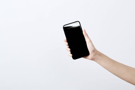 Close up Female hand holding mock up phone isolated white backgroundの写真素材