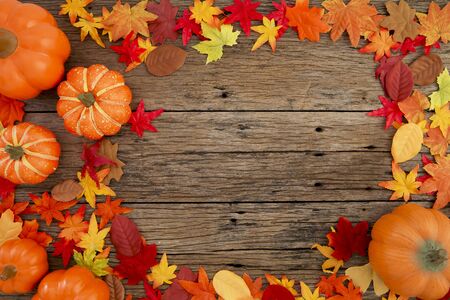 Autumn multicolored  leaves and pumpkins old brown wood table background with copy space, flat lay, minimal conceptの写真素材