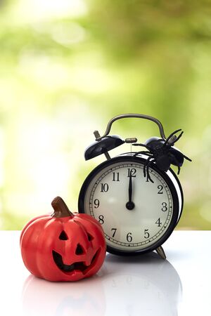 Vintage Clock with spider and pumpkin for Halloween celebration on white background, minimal copy space for textの写真素材