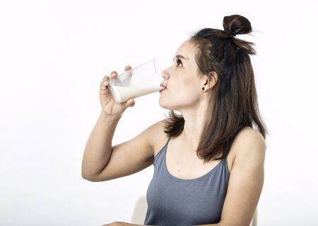 Portrait of beautiful young asian woman with a glass of on table white background, concept  Healthy...