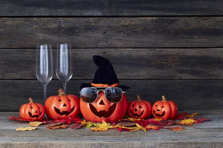 Happy Halloween pumpkin lantern. Trick or treat on a wooden table on a background of old wooden boards. Halloween background. Space for text.の写真素材