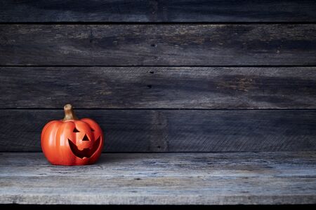 Happy Halloween pumpkin lantern. Trick or treat on a wooden table on a background of old wooden boards. Halloween background. Space for text.の写真素材