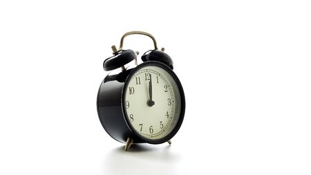 Black alarm clock retro style on white background. concept watch for text message or art work design. pointer in 12 o'clock.の写真素材