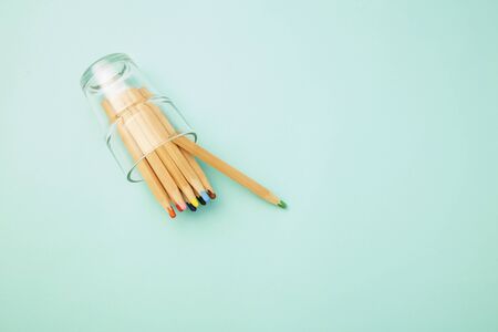 Flat lay photo, Colorful Crayon in glass on pastel pale blue background, World Teachers' Day or Back to school concept, copy space for textの写真素材