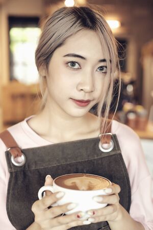 Asian Women Holding Coffee Cup  At Cafe Working woman small business owner or sme concept