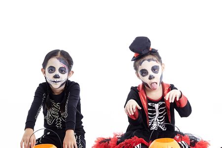 Asian children 5-8 years two children sitting on steps with trick or treat on white backgroundの写真素材