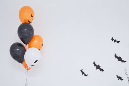 holidays, decoration and party concept - orange, black and white air balloons for halloween with...