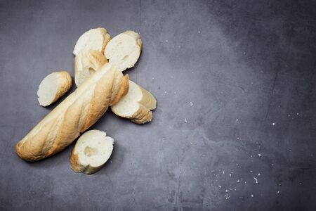 Homemade fresh sliced bread and rolling pin on black tablebackground. Flat lay, top view, copy space for your textの写真素材