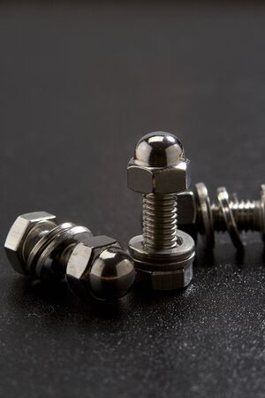 Close-Up of steel nut and bolt sat on black background, copy space for text