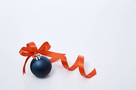 Blue christmas ball with red ribbon isolated on a white background. copy space for text. Winter decoration.の写真素材