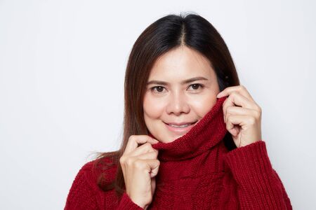Portrait of a smiling asian woman in red sweater white background. for copy spaceの写真素材