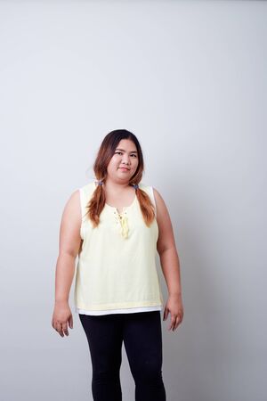 Portrait of Happy beautiful and healthy plump woman on Bright gray background, Diet control concepts For good healthの写真素材