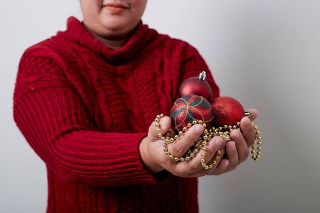 Female hands holding a Christmas balls bright gray backgroundの写真素材
