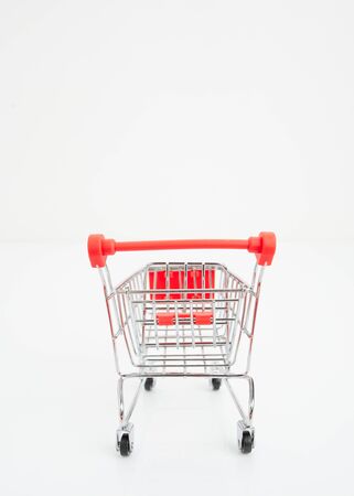 Miniature blank shopping cart and basket on white background. Business idea And shoppingの写真素材