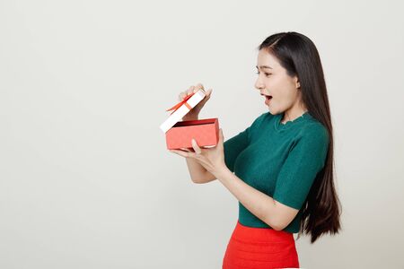 Beautiful Asian woman in in santa hat with many gifts studio shot isolated on bright gray background, copy space for text, Christmas Concept and  new yearの写真素材