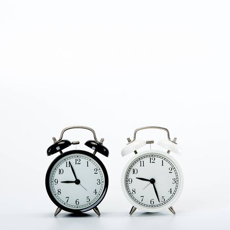 Black vintage alarm clock and White clock on white background  time sale  concept