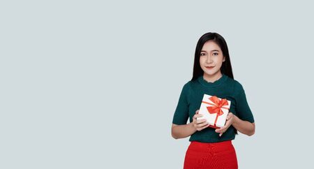 Happy pretty young asian woman holding gift box Pastel green backgroundの写真素材