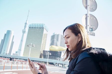 Happy young travel asian woman using mobile phone in Tokyo japanのeditorial素材