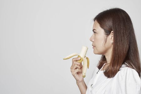 Young asian woman holding bananaの写真素材
