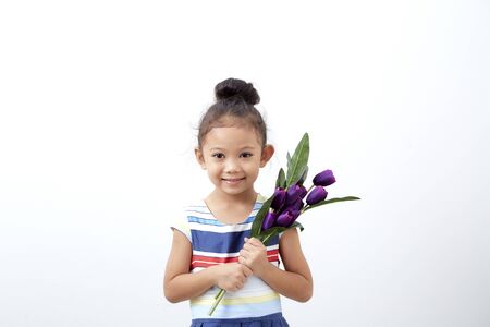 Portrait Happy funny asian cute child girl easter day hand holding  bouquet purple tulip on white background . Happy easterの写真素材