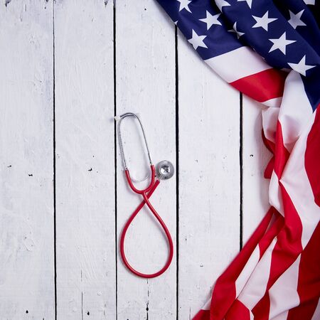 USA flag with red stethoscope on white table, healthcare concept. Corona virus quarantine. Virus Pandemic Protection Conceptの写真素材