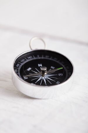 Compass on the white wooden table background, concept for direction, travel, guidance or assistanceの写真素材