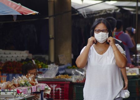Crowd with Asian women in masks for protection against viruses on busy market streets for protection from corona virusの写真素材