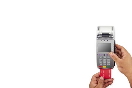 Pay by payment terminal, Men's hand is holding red credit card to terminal on white background top view copy spaceの写真素材