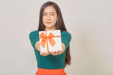 Christmas happy smiling young asian woman holds gift box in handsの写真素材
