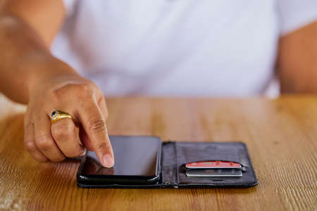 Close-up One personâ€™s hands pointing out data on smart phone screen to another set of hands...