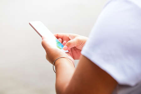 Close-up One personâ€™s hands pointing out data on smart phone screen to another set of hands...