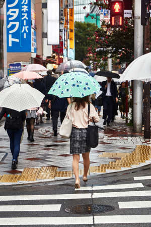Tokyo, Japan Sep 21 2018 Beautiful young woman. Attractive beautiful lady hold an umbrella. Itâs rainy day. Lovely girl is walking at city when light rain. Itâs rainy season. She look so relaxed and happy. copy spaceのeditorial素材