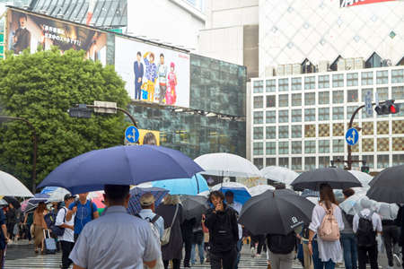 Man with umbrella walking in the rain at Shibuya square.のeditorial素材