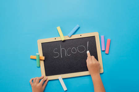 top view hand with chalk blackboard or chalkboard. Back to school concept.の写真素材