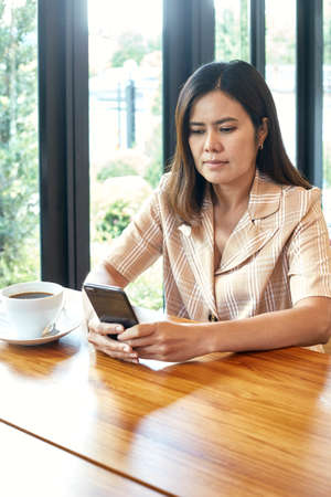 woman in the living room is using a smart phone