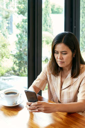 woman in the living room is using a smart phone