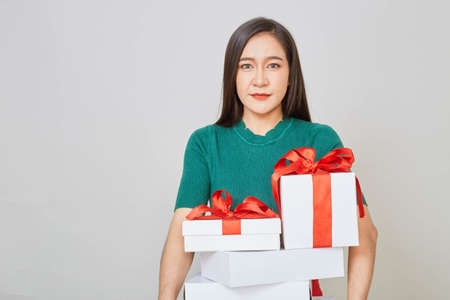 Beautiful asian girl with christmas presents against white background.