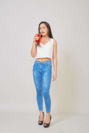 Healthy Asian woman in summer holding a glass of red fruitの写真素材