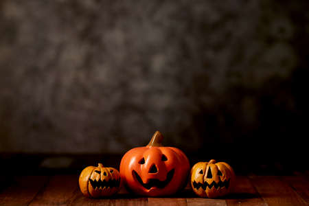 Halloween pumpkin head jack lantern on wooden table dark background. concept holiday halloweenの写真素材