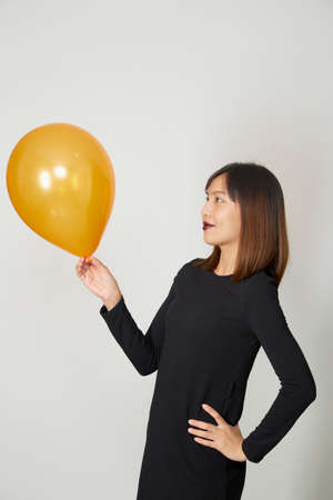Happy Halloween Party Young woman in black witch costume with air balloon