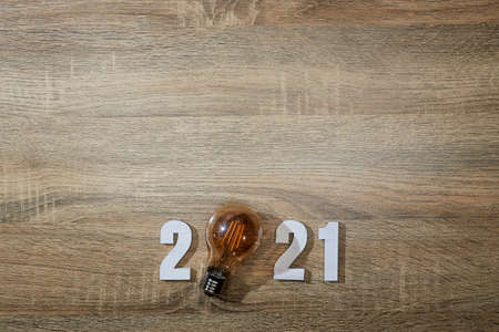 Happy new year 2021. Numbers wood 2021 with led lighting on wooden background concept with top view and copy spaceの写真素材