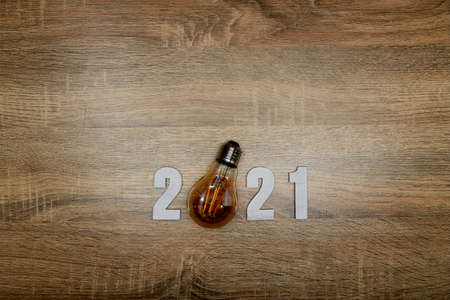 Happy new year 2021. Numbers wood 2021 with led lighting on wooden background concept with top view and copy spaceの写真素材