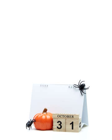 Wooden calendar block disrupted show date 31 october halloween day and toy pumpkin on white background. Halloween conceptの写真素材
