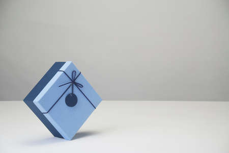Blue paper gift box with a ribbon and bow isolated on whiteの写真素材